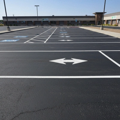 Detailed photo of a well-maintained asphalt parking lot with clear markings and no cracks, reflecting good property management